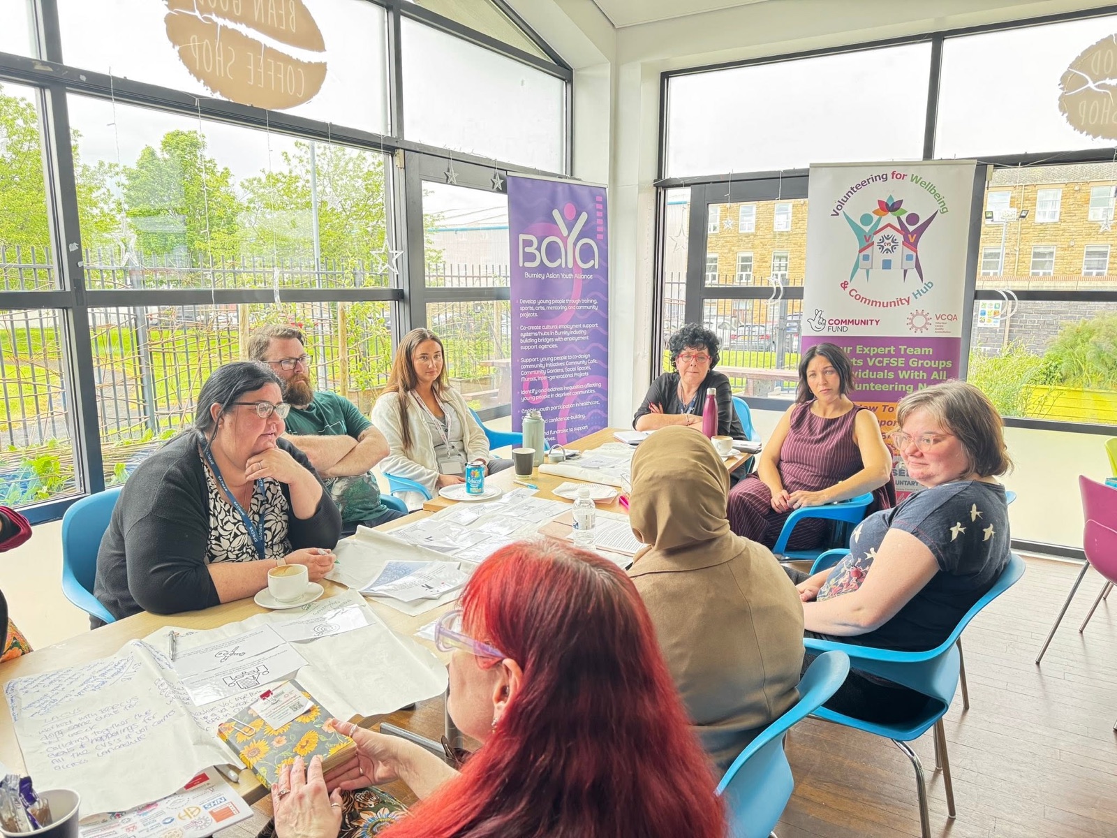 A group taking part in a roundtable discussion in a bright community space.